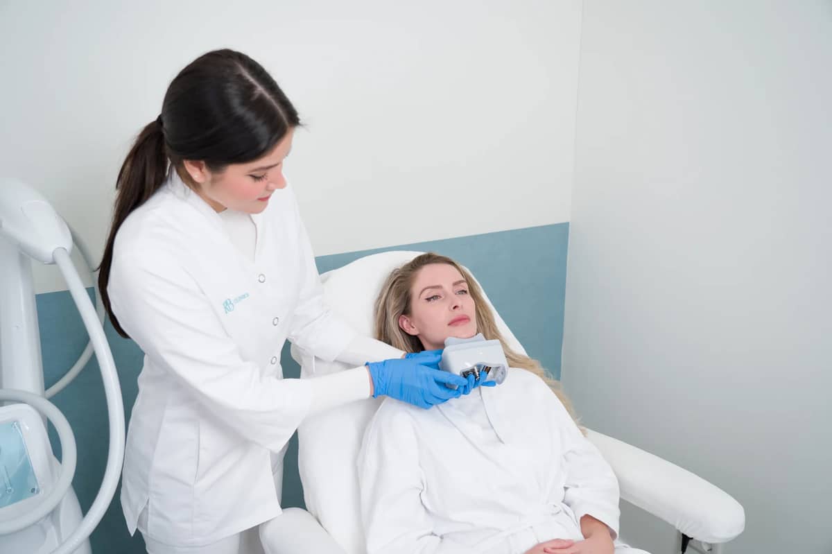 Specialist plaatst de behandelkop voor vet bevriezen op de onderkin